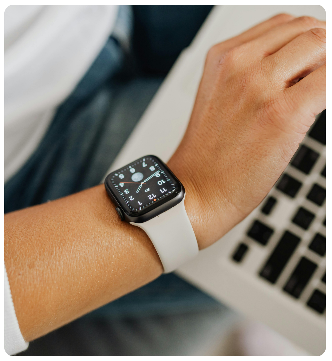 close up image of arm with watch with keyboard in the background